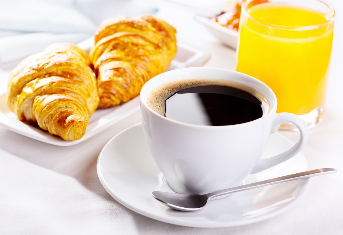 breakfast with cup of coffee, croissants and orange juice